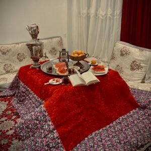 A street photography image of a Yalda Night in Afghanistan, featuring fruits, a poetry book, and a traditional samovar, celebrating the ancient tradition of this night.